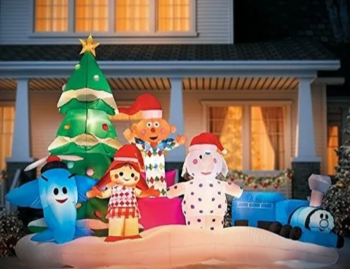 Inflables navideños frente a una casa: árbol, muñecos y tren